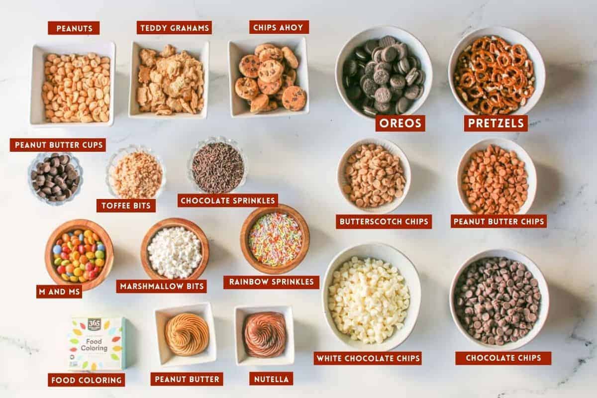 Different topping and mix in various bowls of different shapes and sizes with each ingredient labeled with white text in a dark red box.