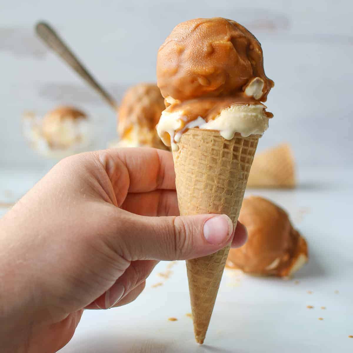 Magic Shell Cookie Butter on an ice cream cone being held in hand