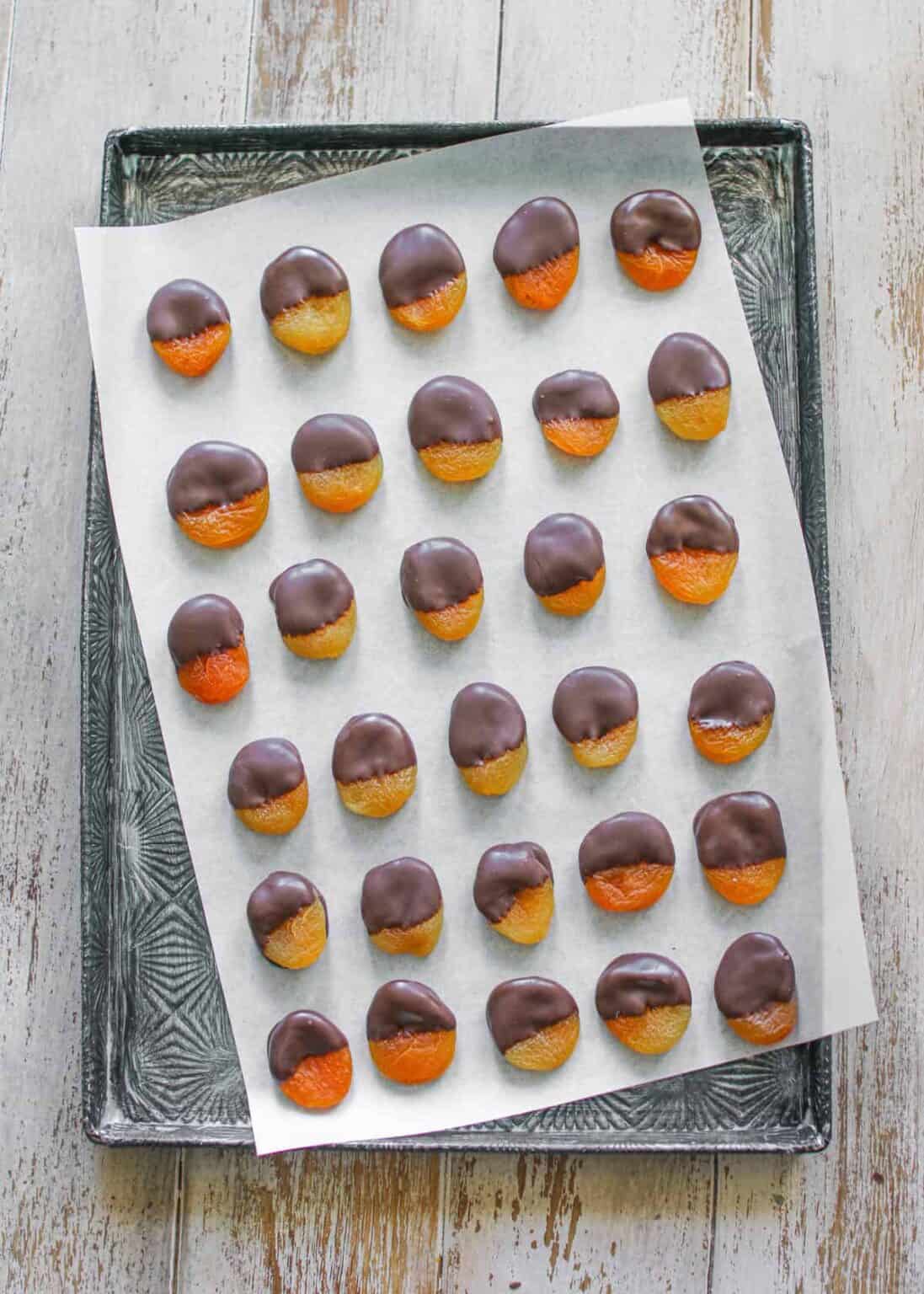 Chocolate Dipped Apricots Make With Mara   Chocolate Dipped Apricots On A White Piece Of Parchment Paper Skewered On A Starburst Metal Baking Pan On A Wood Background 1097x1536 