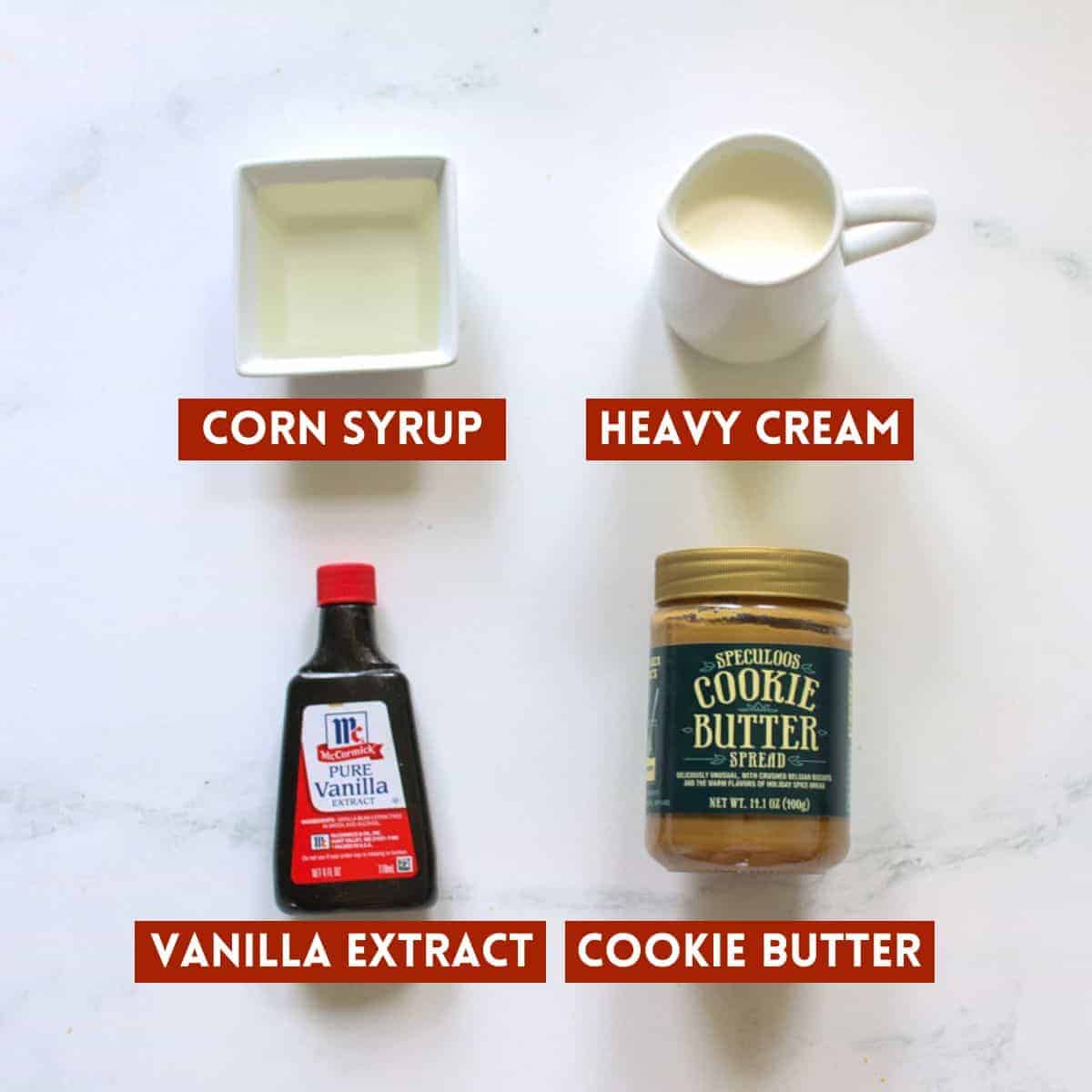 Cookie butter fudge ingredients on a white marble background. Each item is labeled with a dark red rectangle with white text in all caps.
